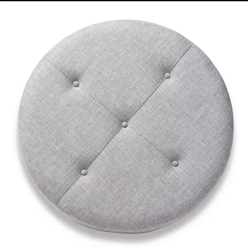 Pouf rotondo rivestito in tessuto, con parte superiore trapuntata e borchie decorative