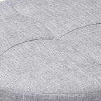 Pouf rotondo imbottito con piano trapuntato e bordatura con borchie