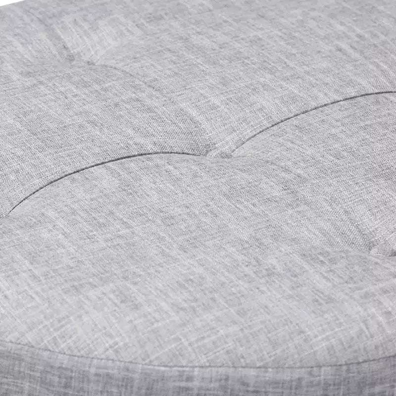 Pouf rotondo rivestito in tessuto, con parte superiore trapuntata e borchie decorative