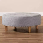 Pouf rotondo imbottito con piano trapuntato e bordatura con borchie
